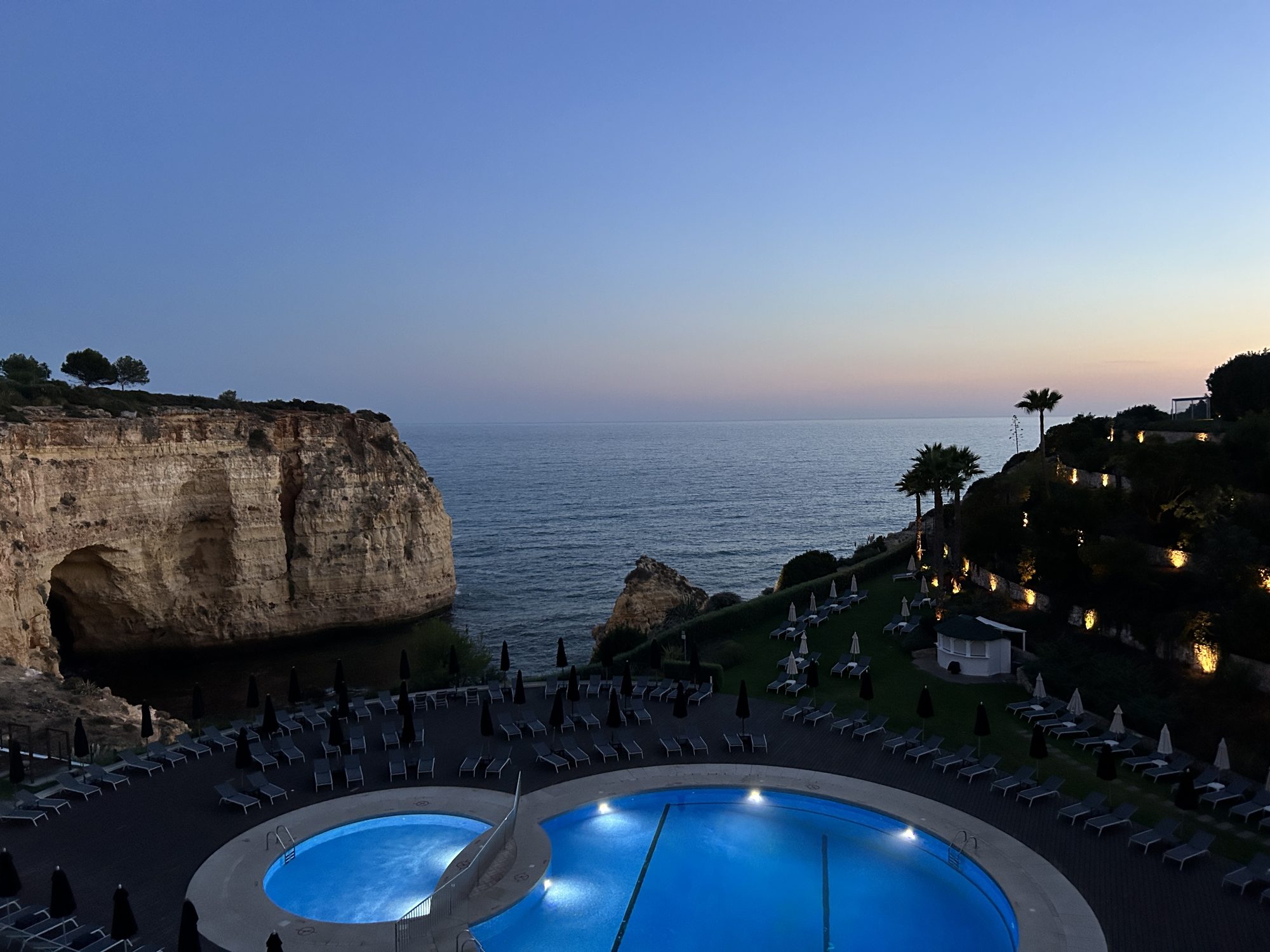 Piscine à flanc de falaise face à l'océan, au crépuscule
